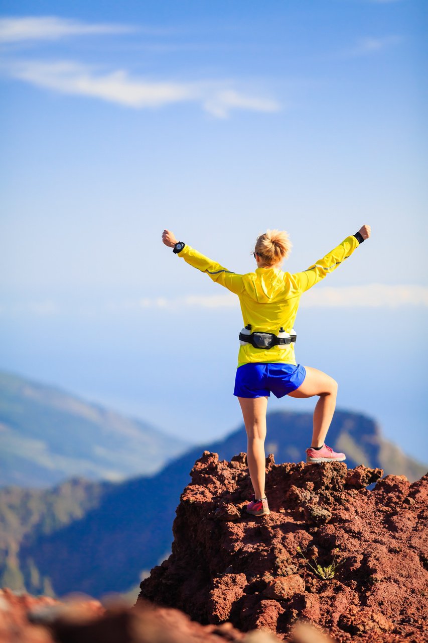 Climbing success, happy woman in mountains